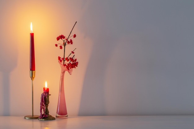 Décor de noël rose avec des bougies allumées dans un intérieur blanc