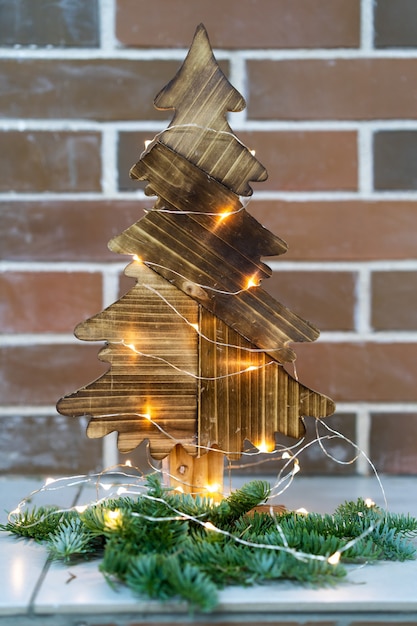 Décor de Noël sapin de Noël en bois sur le fond d'un mur de briques