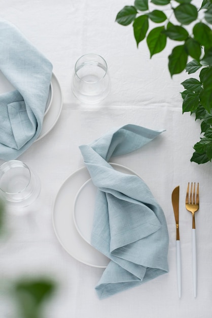 Décor de table avec nappe en lin blanc et serviettes bleu clair, image de mise au point sélective