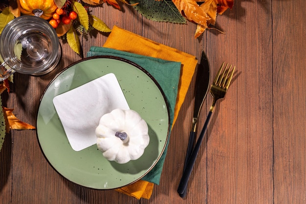 Décor de table de saison avec des citrouilles, des feuilles, des baies, un décor d'automne sur fond en bois.
