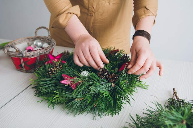 Décorateur de fleuriste faisant la guirlande de Noël