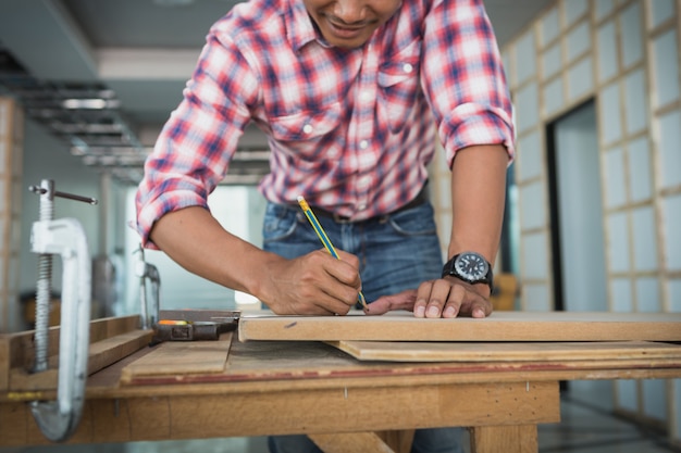 Décorateur travaillant à la conception et à l'inspection du contreplaqué sur le chantier de construction; décorateur vérifiant le matériel pour l'intérieur