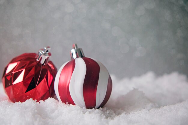 Décoration d'arbre de Noël, boules blanches et rouges, sur la neige sur fond de paillettes.