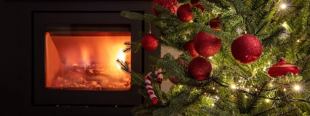 Décoration d'arbre de Noël et lumières vue rapprochée fond de cheminée brûlante