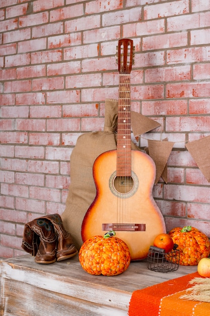 Décoration automnale pour la maison, fête, bottes de cow-boy, citrouilles sur le mur de briques.