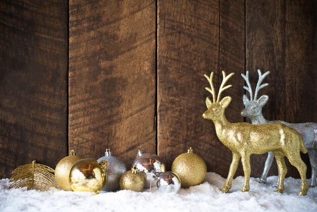 Décoration de boule et renne Noël or argent avec fond de bois