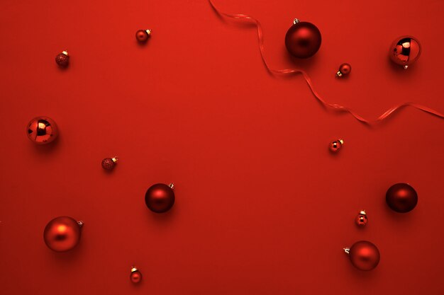 Photo décoration de boules de noël rouges sur fond de papier rouge avec espace de copie pour le nouvel an et joyeux noël