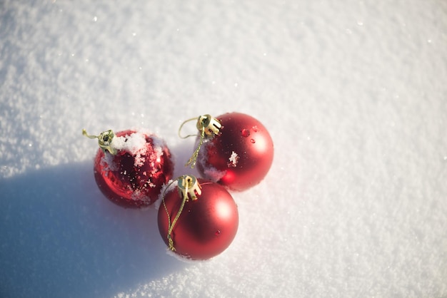 décoration de boules rouges de noël sur fond de neige fraîche sur une belle journée d'hiver ensoleillée