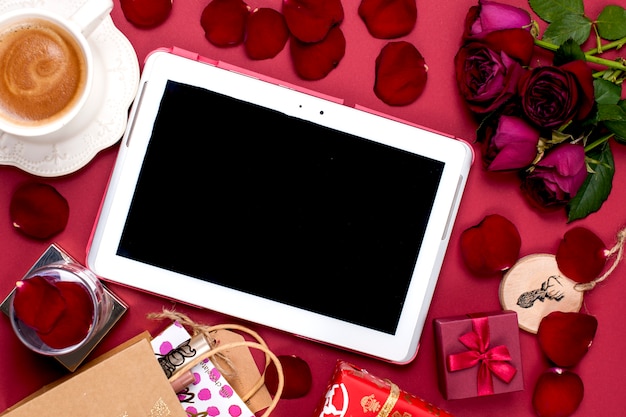 Décoration et cadeau de Noël. Café parfumé du matin et pétales de rose. Vue de dessus. Différents sujets sur fond rouge. Espace copie, mise à plat,