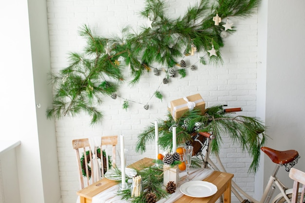 Décoration du Nouvel An de la cuisine et du salon Le soleil brille à travers la fenêtre dans l'ombre Cuisine festive dans les décorations de Noël Bougies branches d'épinette supports en bois vélo