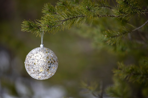 La décoration du nouvel an est suspendue à un arbre de noël dans la nature. photo de haute qualité