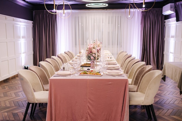 Décoration élégante de la table au restaurant nappe rose couverts élégants et belles fleurs