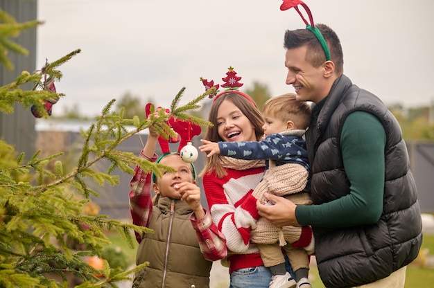 Une décoration familiale un arbre du nouvel an ensemble et à l'air excité