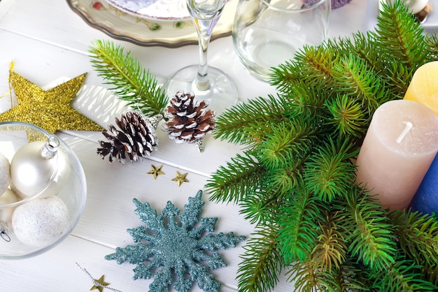 Décoration de fête sur la table de Noël avec des bougies, une lanterne, de la vaisselle