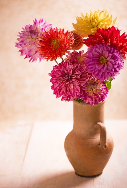 Photo décoration de fleurs de dahlia en jaune et orange dans des pots en terre cuite.