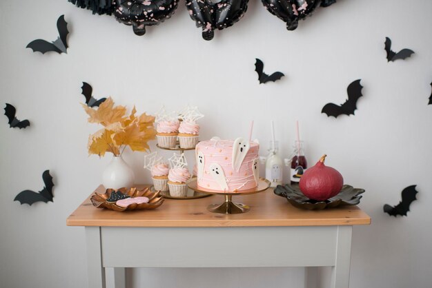Décoration d'Halloween, sweet table, gâteau fantôme et cupcakes. Le décor d'une fête d'enfants.