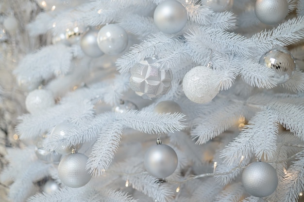 Décoration avec des jouets de Noël et des branches de sapin. Boules de Noël de style argenté et cadeaux emballés