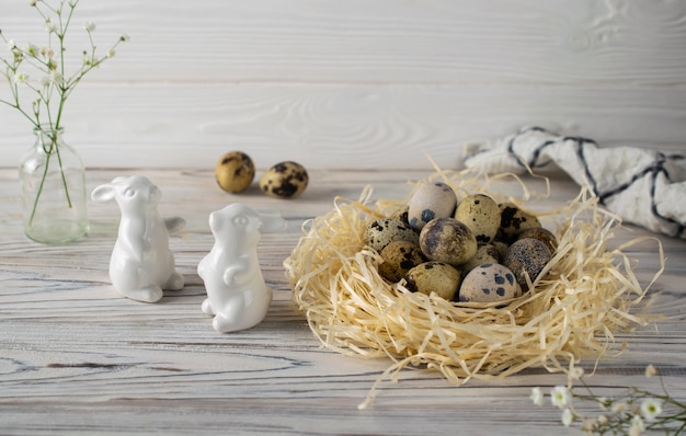 Décoration joyeuse Pâques festive avec des œufs de caille et des lapins en céramique