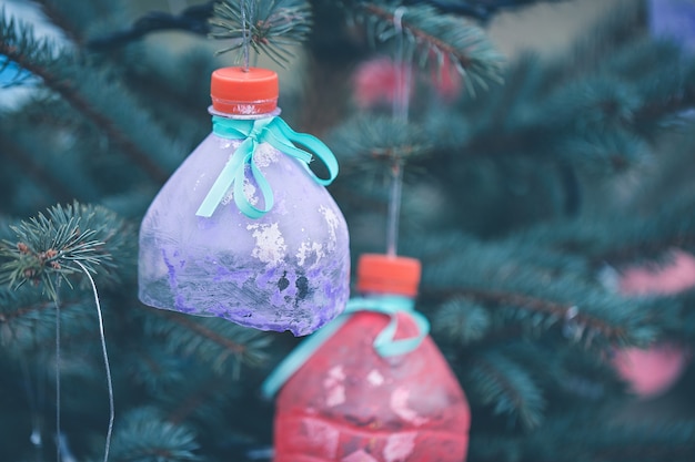 Décoration à la main de bouteille d'eau sur l'arbre de Noël comme concept de recyclage et zéro déchet