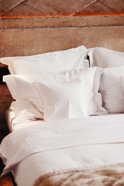 Décoration de maison et design d'intérieur lit avec literie blanche dans une chambre de luxe linge de lit service de blanchisserie et détail de meubles