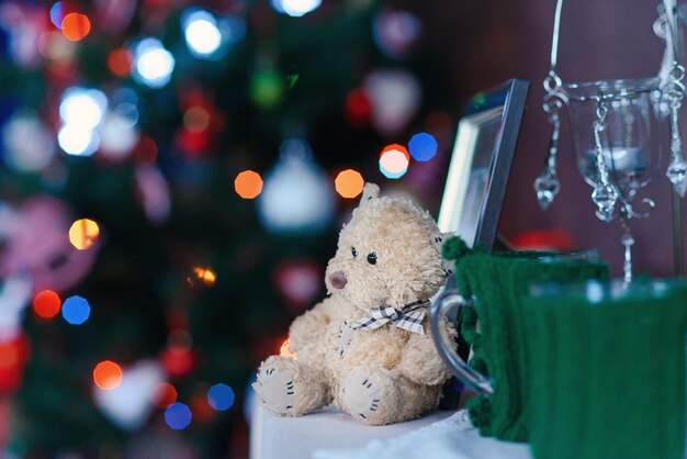 Décoration de la maison de Noël et du Nouvel An ours en peluche moelleux au premier plan et lumières de Noël allumées