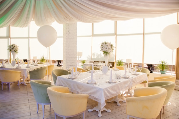 Décoration de mariage, tables de mariage au restaurant avec des fleurs blanches et d'énormes ballons blancs