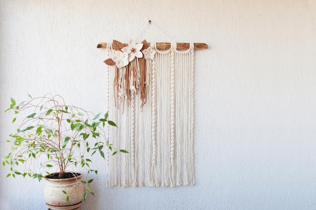 Photo décoration murale en macramé fait main 100 coton avec bâton en bois accroché sur un mur blanc