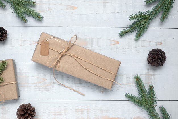 Décoration de Noël, boîte de cadeau et branches d&#39;arbres de pin sur fond en bois