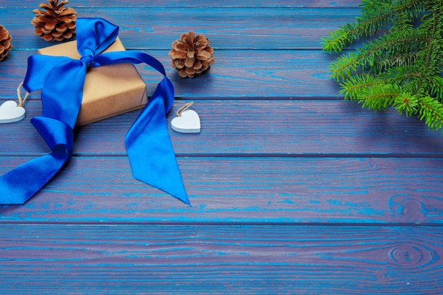 Décoration de Noël, boîte de cadeau et branches d'arbres de pin sur fond en bois