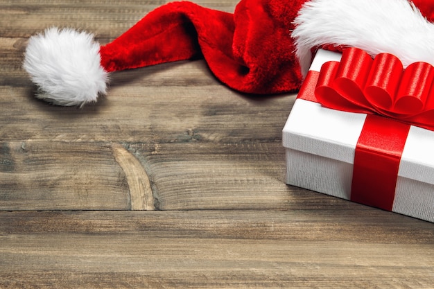 Décoration de Noël et boîte-cadeau avec noeud de ruban rouge sur fond de bois