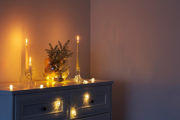 Décoration de Noël avec des bougies allumées dans un intérieur blanc