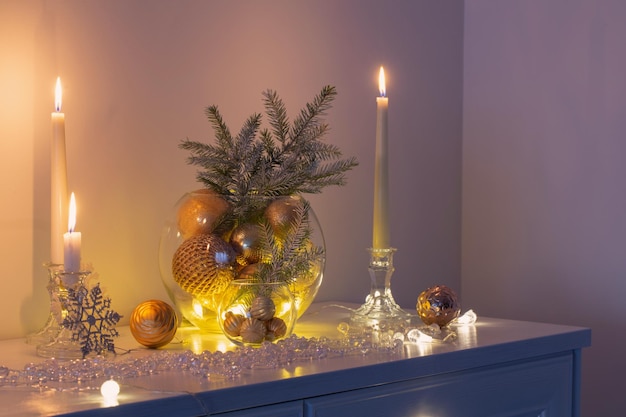 Décoration de Noël avec des bougies allumées dans un intérieur blanc