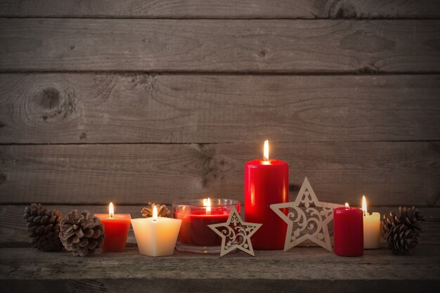 Décoration de Noël avec des bougies rouges sur fond en bois