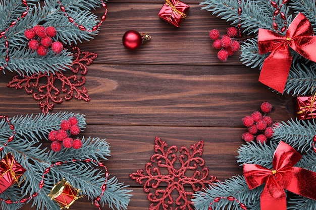 Décoration de Noël. Branche de sapin avec des boules, des cadeaux et des arcs sur un fond marron