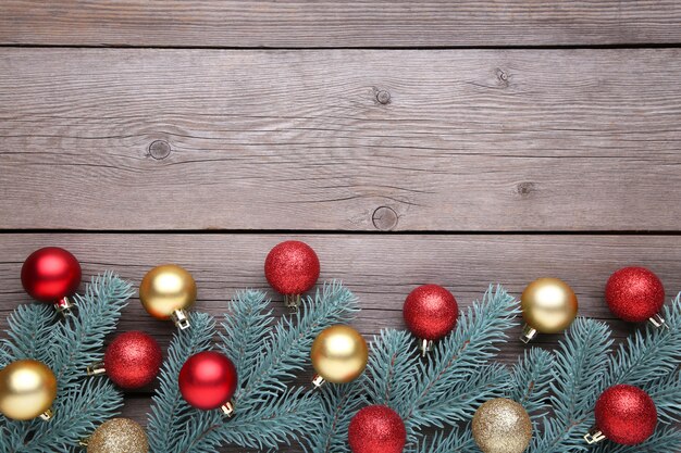 Décoration de Noël. Branche de sapin avec boules, petits cadeaux et noeuds sur fond gris