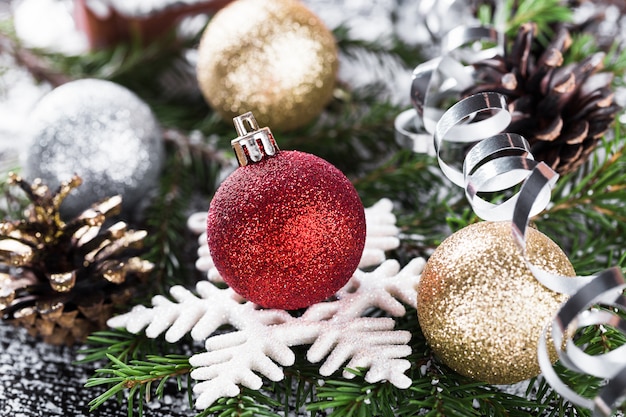 Décoration de Noël avec une branche de sapin, des cônes et des boules