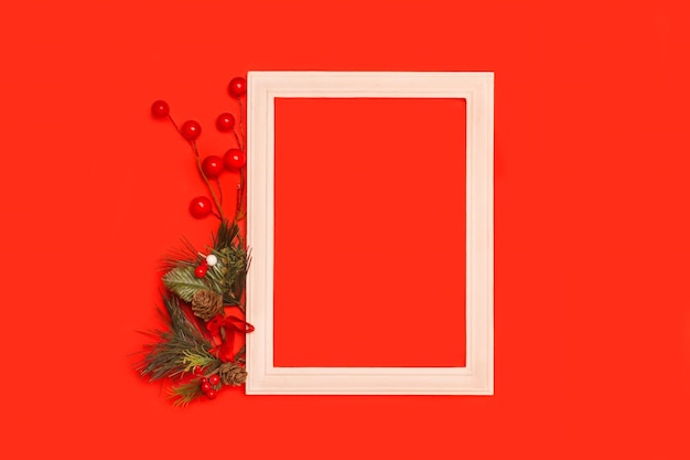 Une décoration de noël avec un cadre photo en bois sur fond rouge avec espace de copie