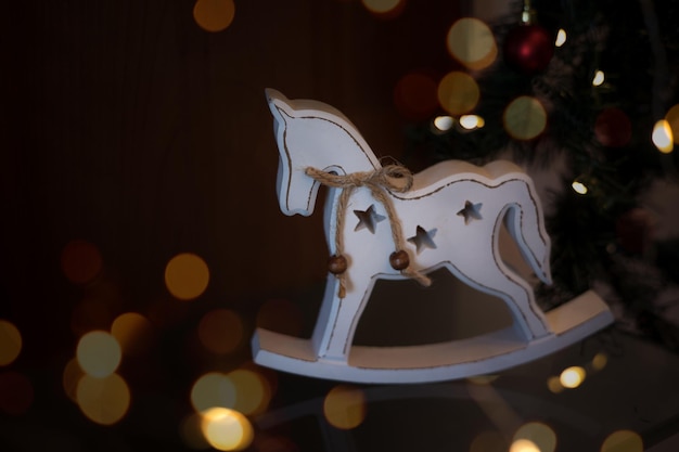 Décoration de Noël cheval blanc sur fond sombre con bokeh et espace de copie pour le texte.