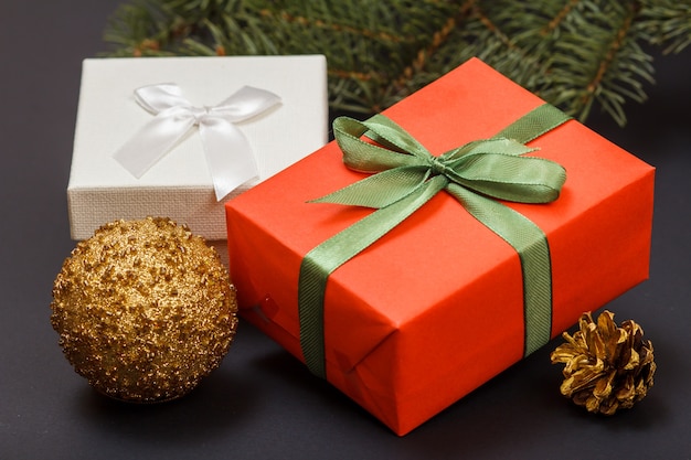 Décoration de Noël. Coffrets cadeaux, boule de jouet, cône et branche de sapin sur fond noir. Vue de dessus. Concept de carte de voeux de Noël.
