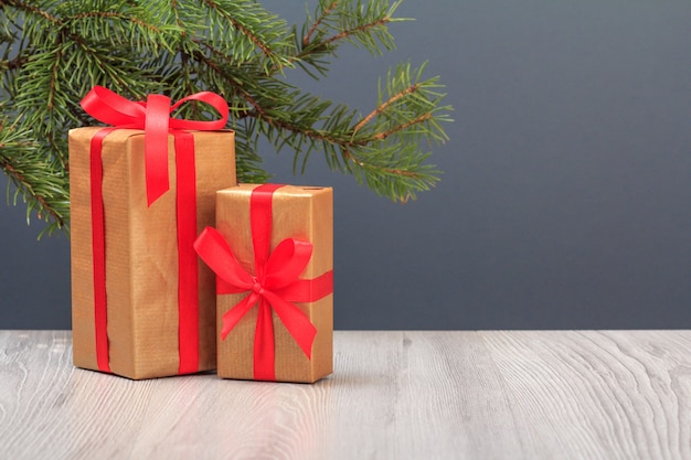 Photo décoration de noël. coffrets cadeaux et branche de sapin sur fond gris. concept de carte de voeux de noël.