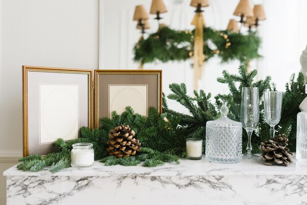 Photo décoration de noël dans la maison décoration cadre photo branches d'épinette verres bougies et cônes