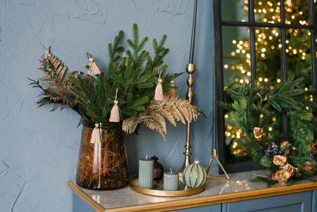 Photo décoration de noël dans le salon intérieur branches d'arbre de noël bougies sur le coffre bleu