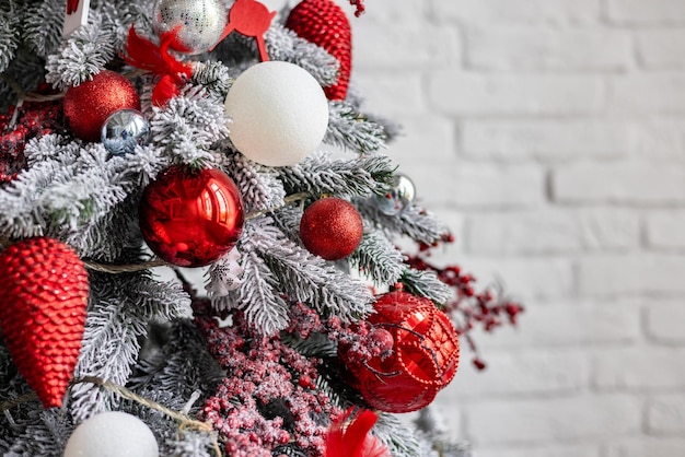 Décoration de Noël du nouvel an rouge et blanc sur l'arbre en gros plan boules de verre et guirlandes dans le