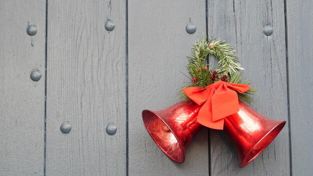 Décoration de noël et du nouvel an ruban rouge pin ou sapin et cloches sur la porte ou le portail