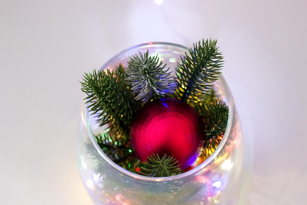 Décoration de Noël faite de branches d'épinette et de boules rouges Décor de Noël dans un vase transparent sur fond blanc