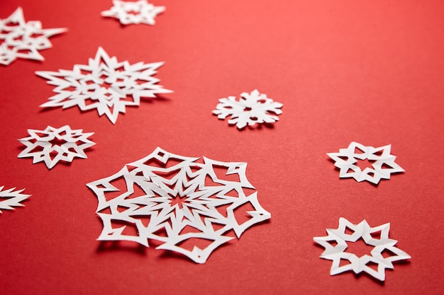 Décoration de Noël avec des flocons de papier blanc sur fond rouge