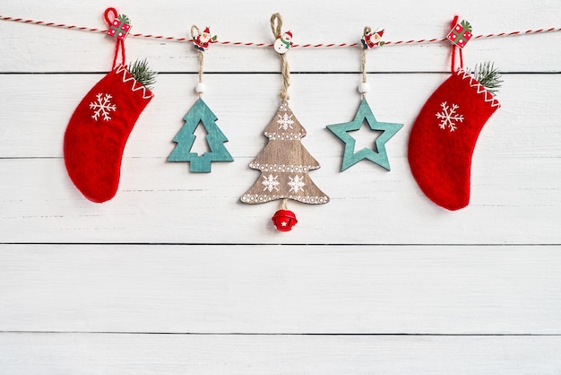 Décoration de Noël sur fond en bois blanc. Chaussettes de Noël rouges et ornement de Noël en bois. Espace de copie, vue de dessus