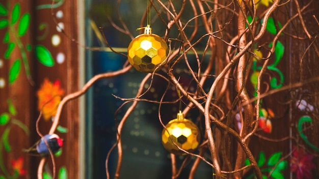 Décoration de Noël moderne avec des boules dorées et des branches naturelles au lieu d'un arbre de Noël.