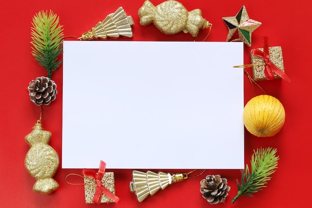 Décoration de Noël et note de papier vide sur fond rouge.