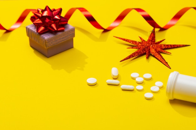 Décoration de Noël avec des pilules blanches et une bouteille comme symbole de la célébration de l'infection Covid19